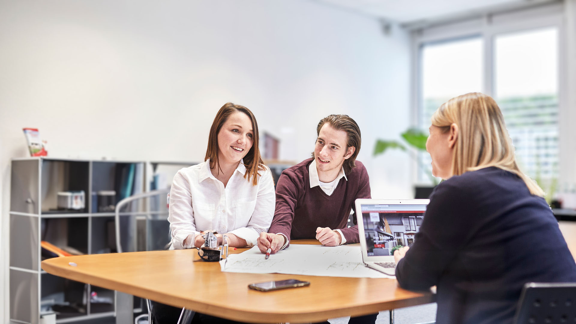 Direkte Ansprechpartner bei einer Besprechung im Büro mit Plan